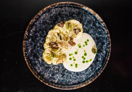 baked cauliflower with herbs and sauceの写真素材