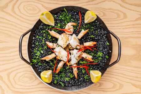 SPANISH BLACK RICE PAELLA WITH SQUID INK BASED BROTHの写真素材