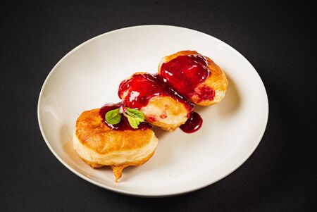 pancakes with berries sauce on black backgroundの写真素材