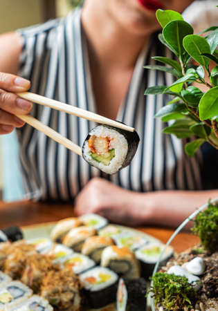 woman eating sushi in the restaurantの写真素材