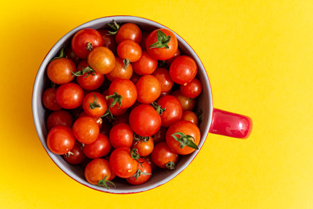 small cherry tomatoes on the yellow background