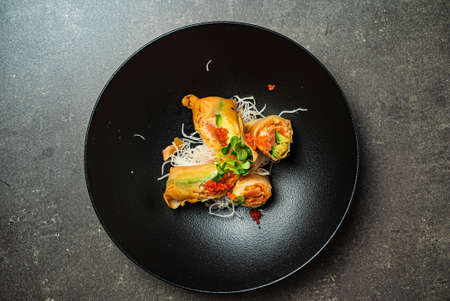 asian spring rolls on black plateの写真素材