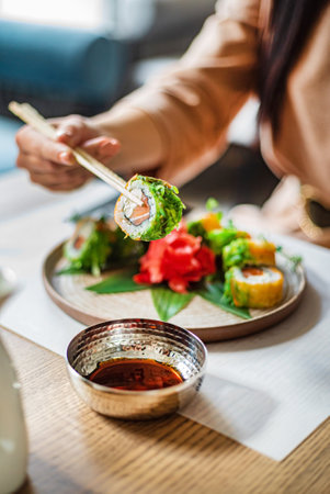 woman eating sushi in the restaurantの写真素材