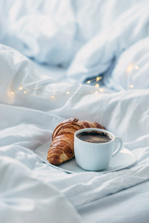 cup coffee with croissant in the bedの写真素材