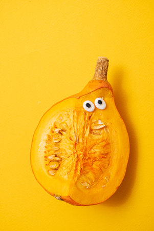 pumpkin with eyes on the yellow backgroundの写真素材
