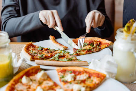 friends eating pizza in a indoor cafeの写真素材