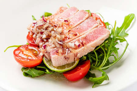 tuna fillet with salad on white plateの写真素材