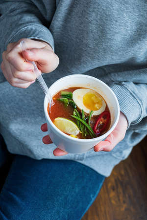 woman eating asian soup in cafeの写真素材