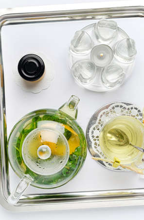 Teapot and cup of herbal tea with fresh mint flowersの写真素材