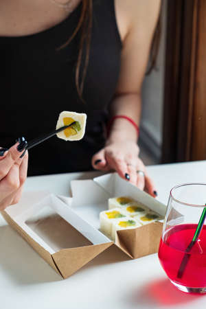 woman eating sushi in the cafeの写真素材