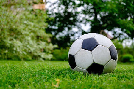 Close-up view of football ball on green grass lawnの写真素材
