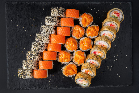 Assortment of fresh prepared sushi on black background.の写真素材