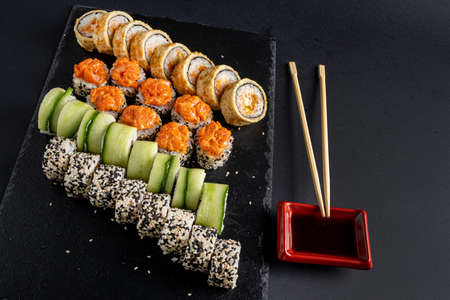 Assortment of fresh prepared sushi on black background.の写真素材