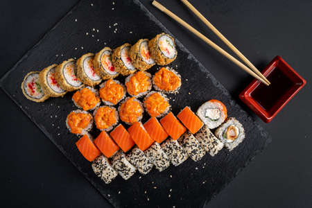 Assortment of fresh prepared sushi on black background.の写真素材