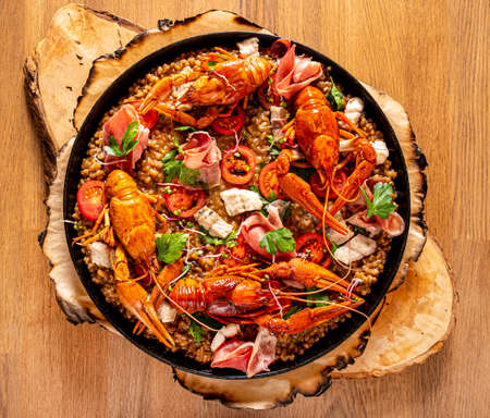 Catalan paella with shrimp and blue fideua on a rustic wooden background.の写真素材