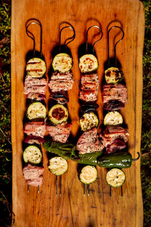 Close up of delicious pork on wooden skew with fresh vegetablesの写真素材