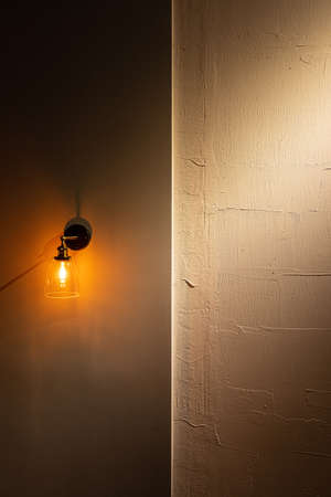Vintage golden light bulb with shine light on dark background.の写真素材