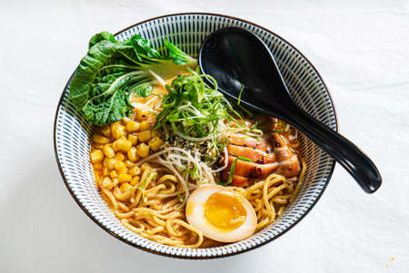 Asian noodles soup, ramen with chicken, tofu, vegetables and egg, close-up.の写真素材