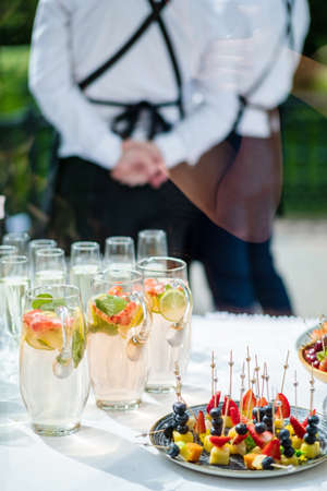 waitress catering service. female staff servicing dish full of snack food at restaurant eventの写真素材