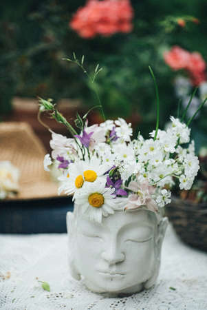 meadow flowers in the Buddha vaseの写真素材