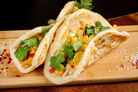 Mexican food quesadillas with chicken and cheese served on rustic wooden chopping boardの写真素材