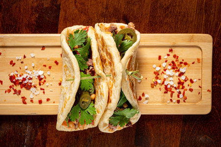 Mexican food quesadillas with chicken and cheese served on rustic wooden chopping board