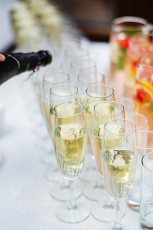 Stylish champagne glasses and food appetizers on table at wedding reception