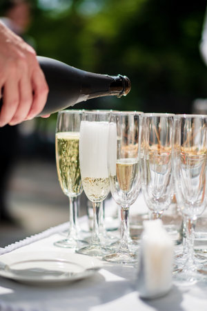 Stylish champagne glasses and food appetizers on table at wedding receptionの写真素材