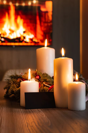 Burning candles on table in room decorated for Christmasの写真素材