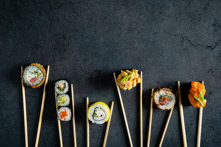 sushi with chopsticks on the black backgroundの写真素材