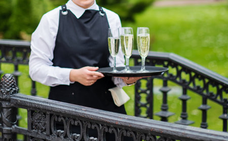 waiter with champagne glasses on trayの写真素材
