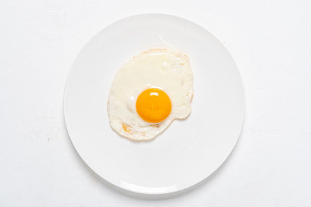 fried egg on the white plateの写真素材