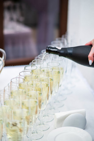 Stylish champagne glasses and food appetizers on table at wedding receptionの写真素材