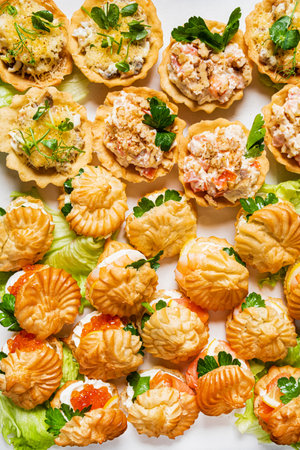 Different light snack on wooden tray on wedding partyの写真素材