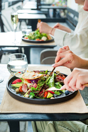 woman eating salad in the cafeの写真素材