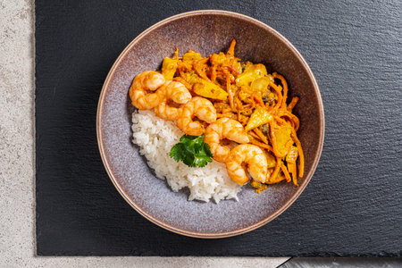 Shrimps with sweet potato and carrot on top of cooked riceの写真素材