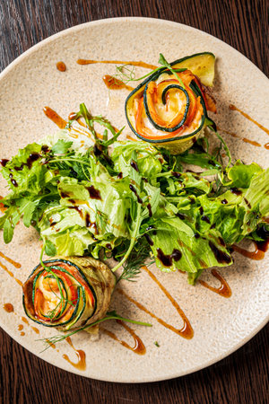 zucchini rolls with salad and sauceの写真素材