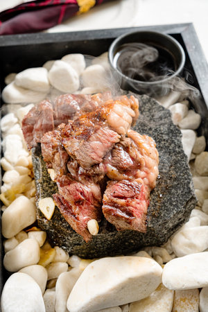 meat with sauce on the hot stonesの写真素材