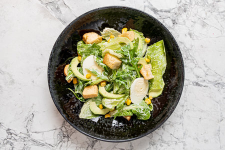 caesar salad in the black bowlの写真素材