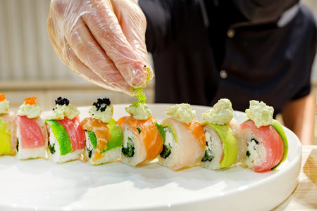 Sushi rolls on a white plate in the hands of a chefの写真素材