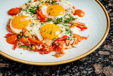 fried eggs with tomatoes and herbsの写真素材