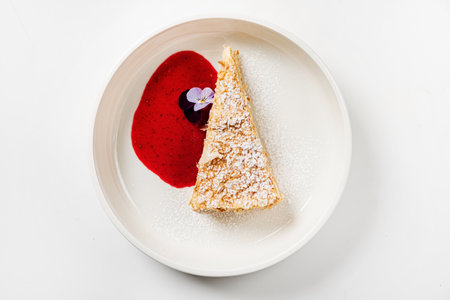 cake with strawberry sauce and edible flowerの写真素材