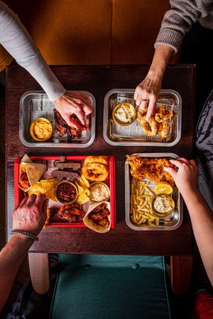 friends eating fast food in cafeの写真素材