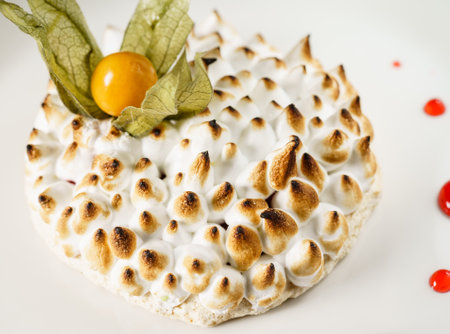 meringue pastry with physalis on white plateの写真素材