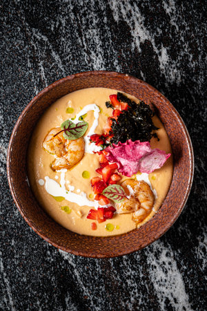 A vibrant bowl of shrimp, colorful toppings, and creamy sauce for a delightful experience.の写真素材