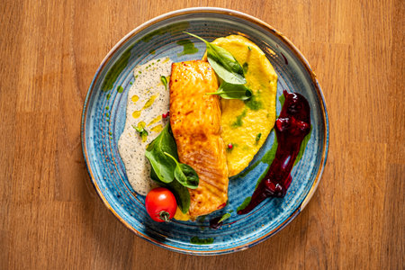 Elegant salmon fillet adorned with fresh ingredients and vibrant garnishes.の写真素材