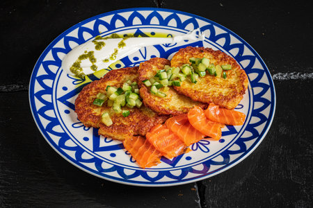 Savory pancakes with fresh cucumber and salmon, highlighting vibrant colors and textures.の写真素材