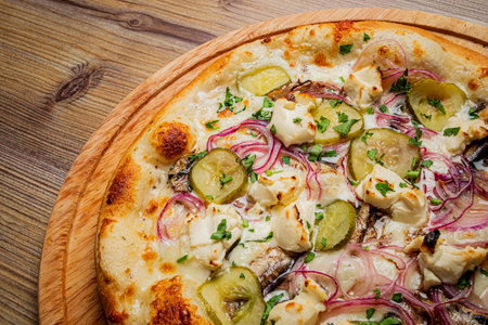Enjoy the gourmet pizza with pickles and creamy cheese, baked to perfection!の写真素材