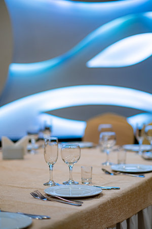 A beautifully arranged dining table showcases fine china, glassware, and modern decorative elements.の写真素材