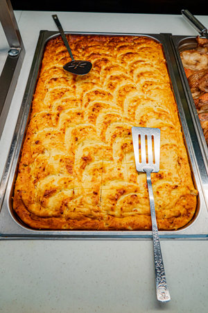 Golden-brown casserole emerges from the kitchen, inviting hungry guests to savor its rich flavors.
